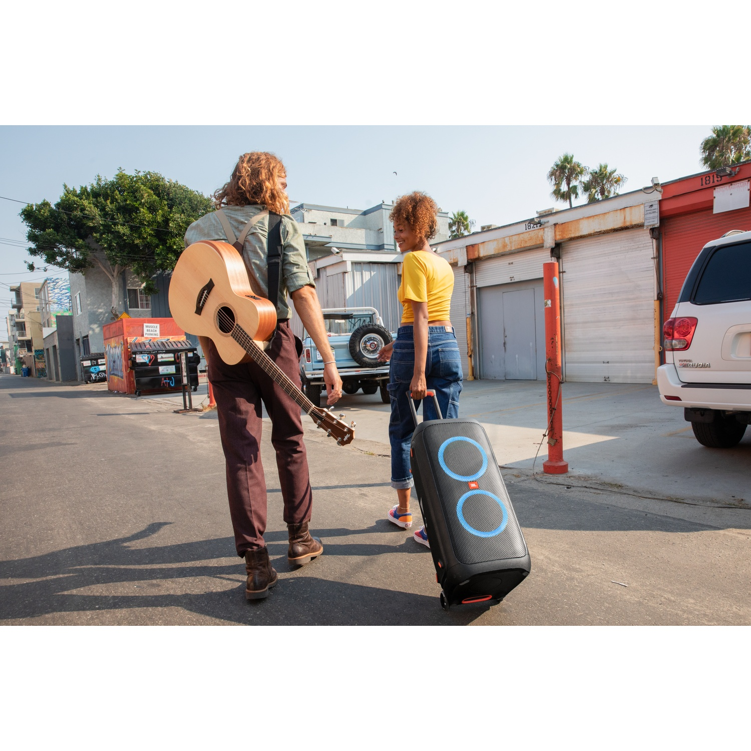 Homme avec guitare et femme avec enceinte marchant dans la rue
