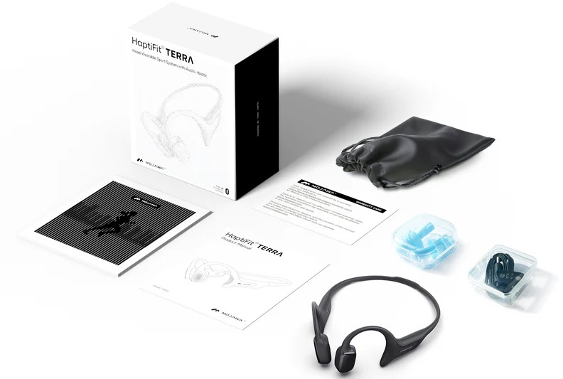 Casque HapticFit TERRA, boîte, manuels, embouts, étui de chargement et pochette noire sur fond blanc.