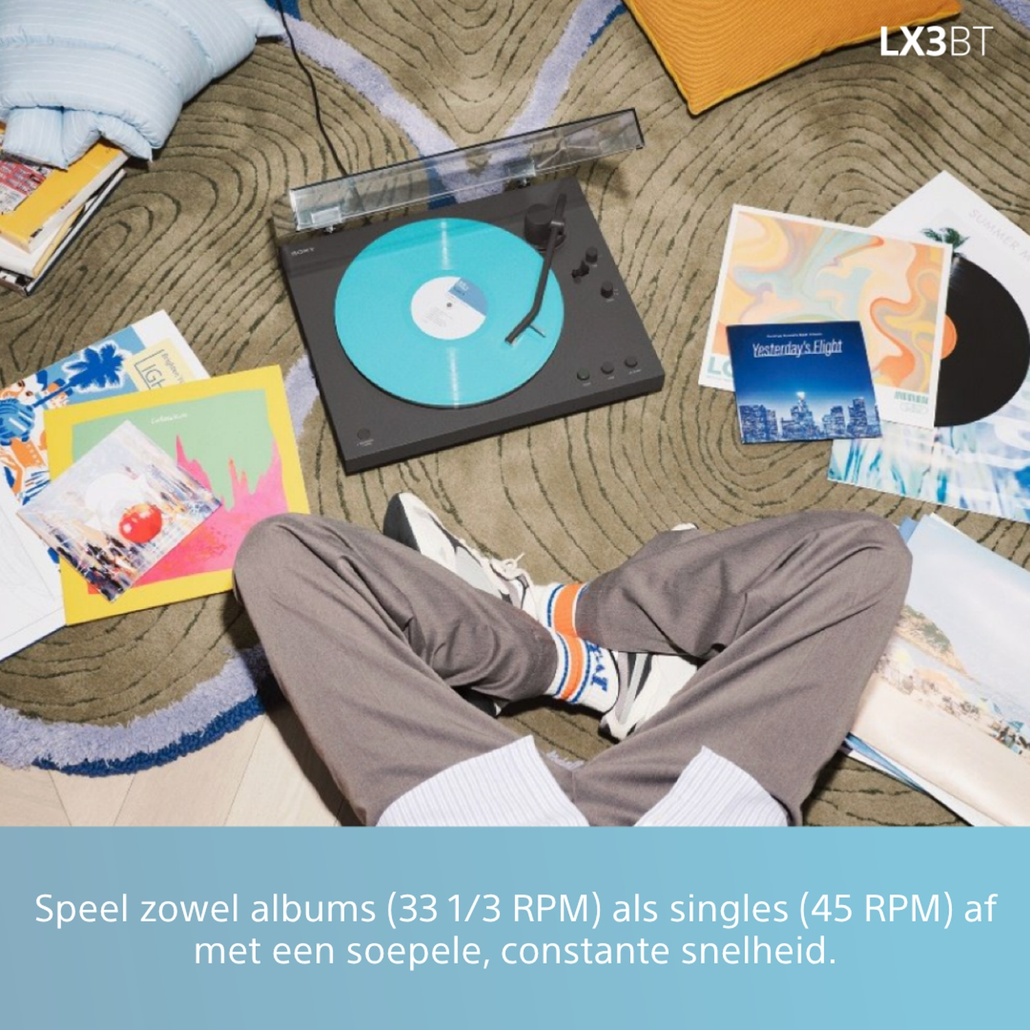 Person listening to records on a turntable with blue vinyl.