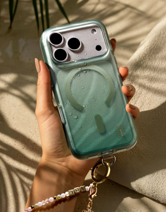 Eine Hand hält ein mintgrünes Handy mit Wassertropfen. Eine Perlenkette hängt daran.