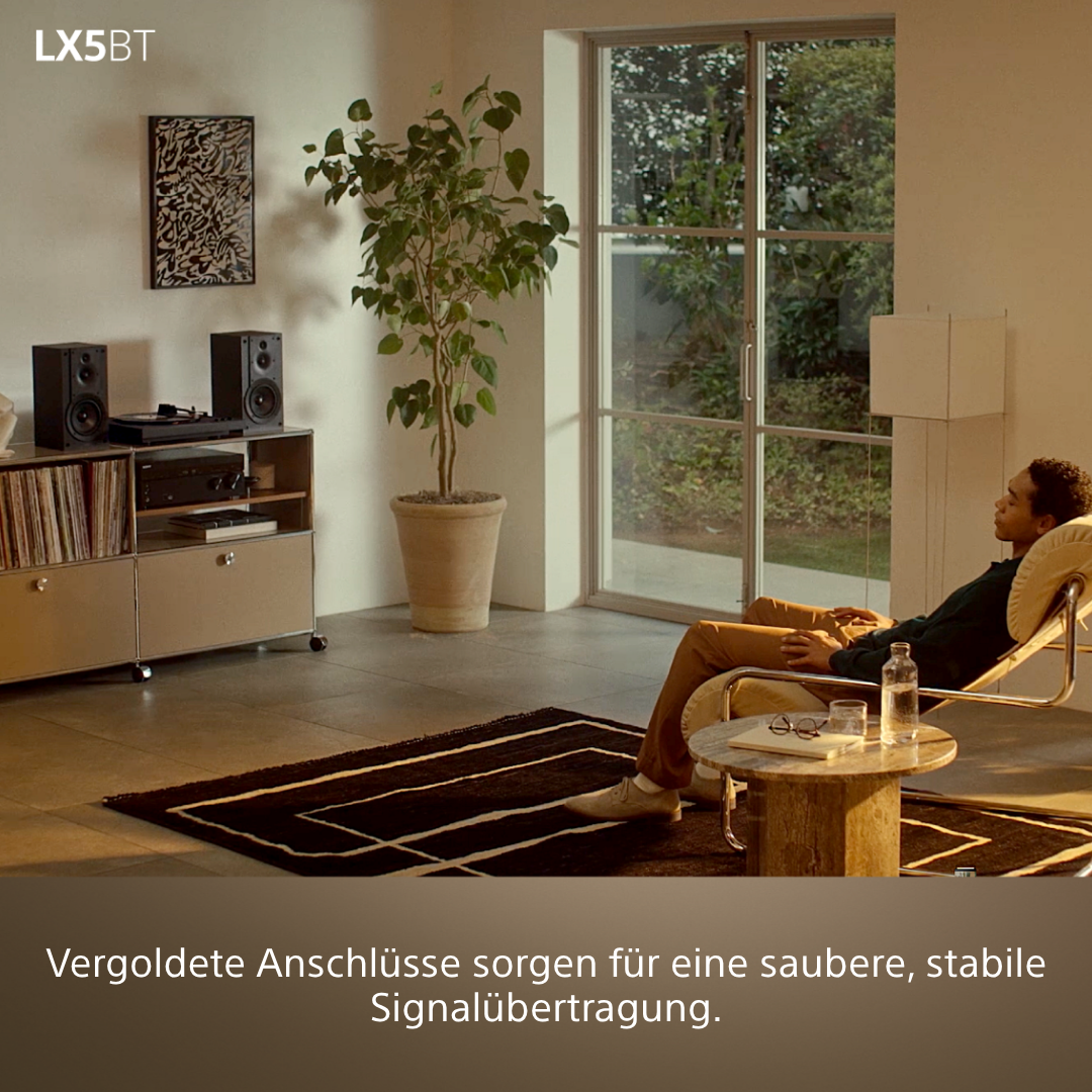 Mann entspannt sich in einem Sessel, Stereoanlage im Hintergrund.
