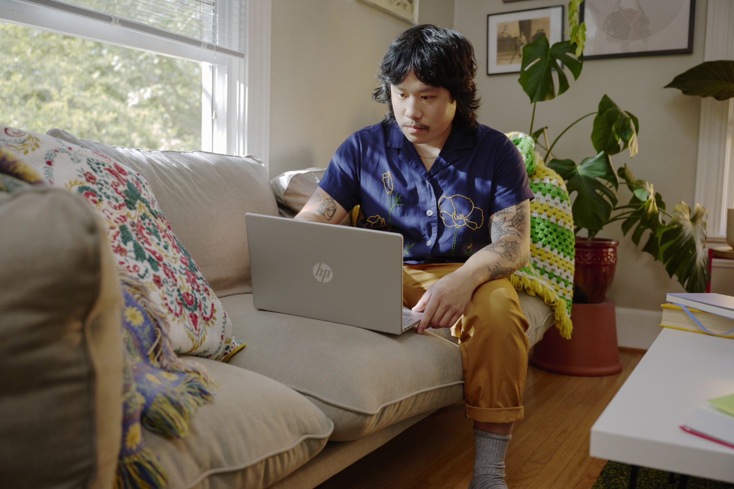 Man sits on couch with laptop.