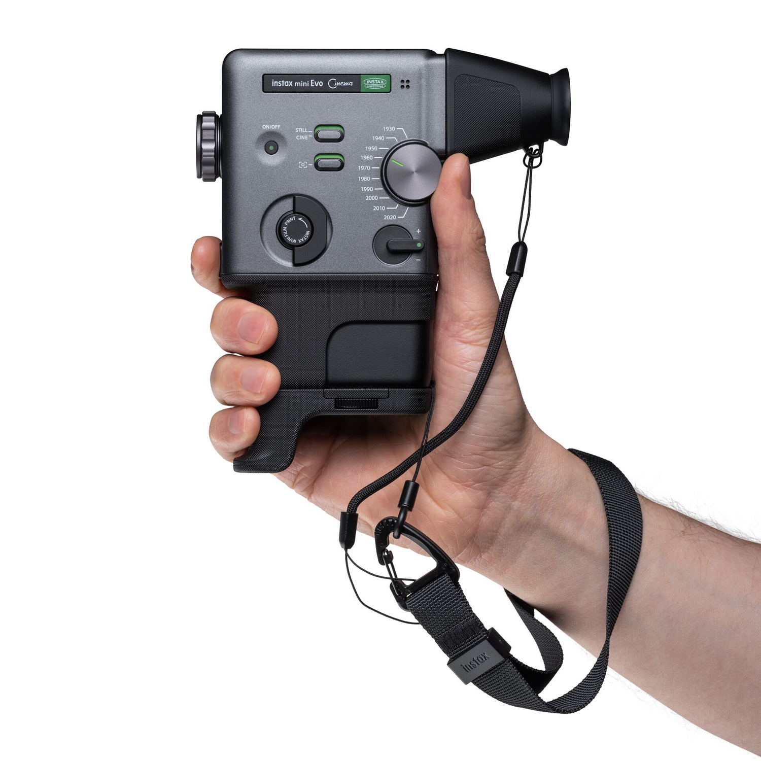 Una mano sostiene una cámara Instax Mini Evo gris con correa.