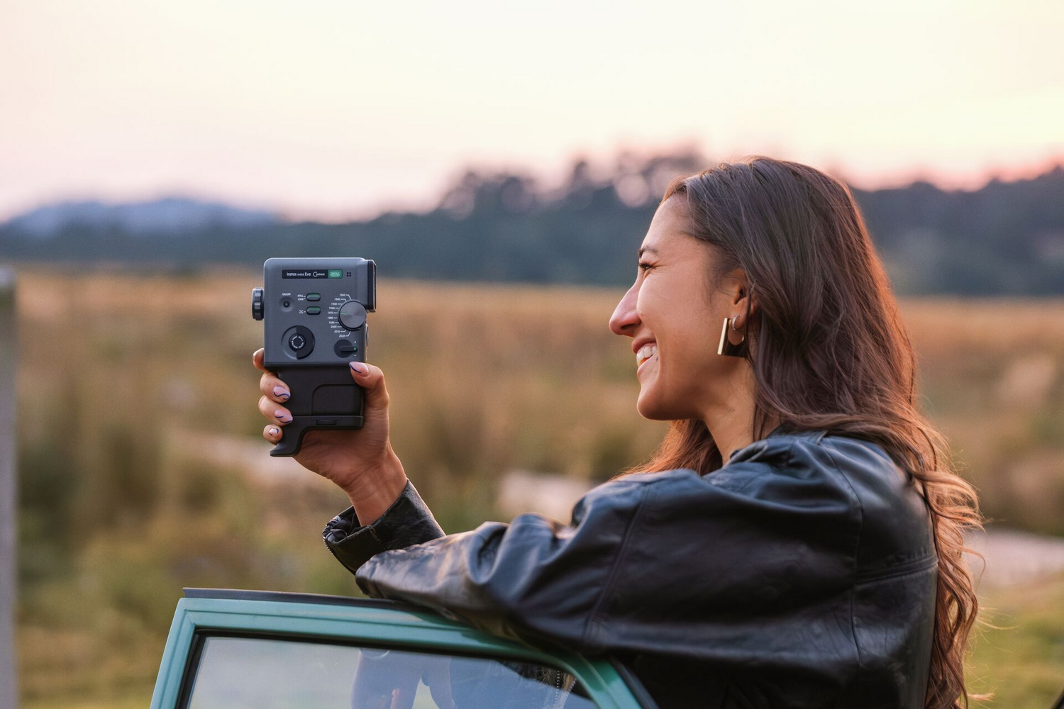 Mujer con cámara al aire libre al atardecer.