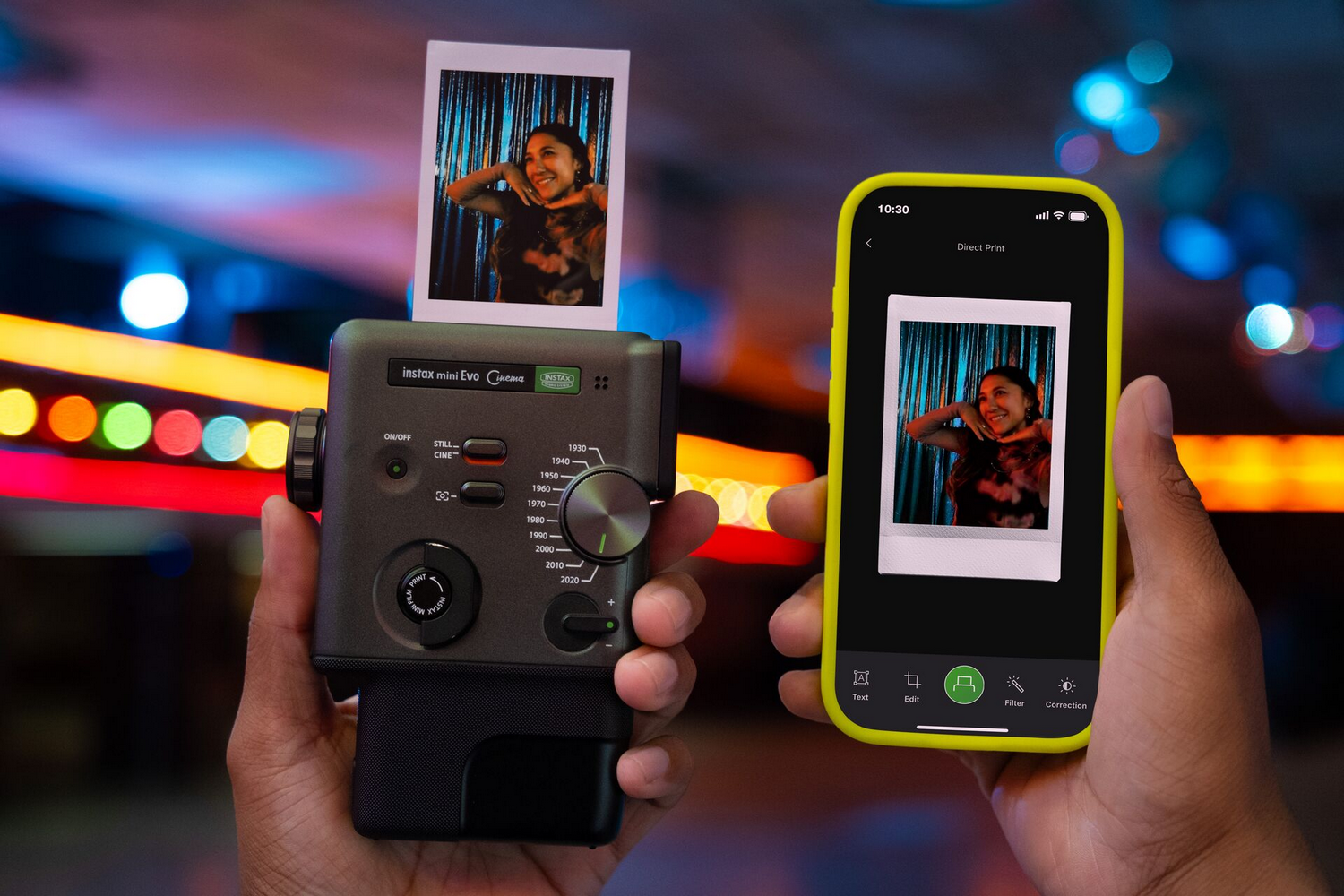 Una persona sostiene una cámara Instax mini Evo y un smartphone con foto. Luces coloridas se difuminan al fondo.