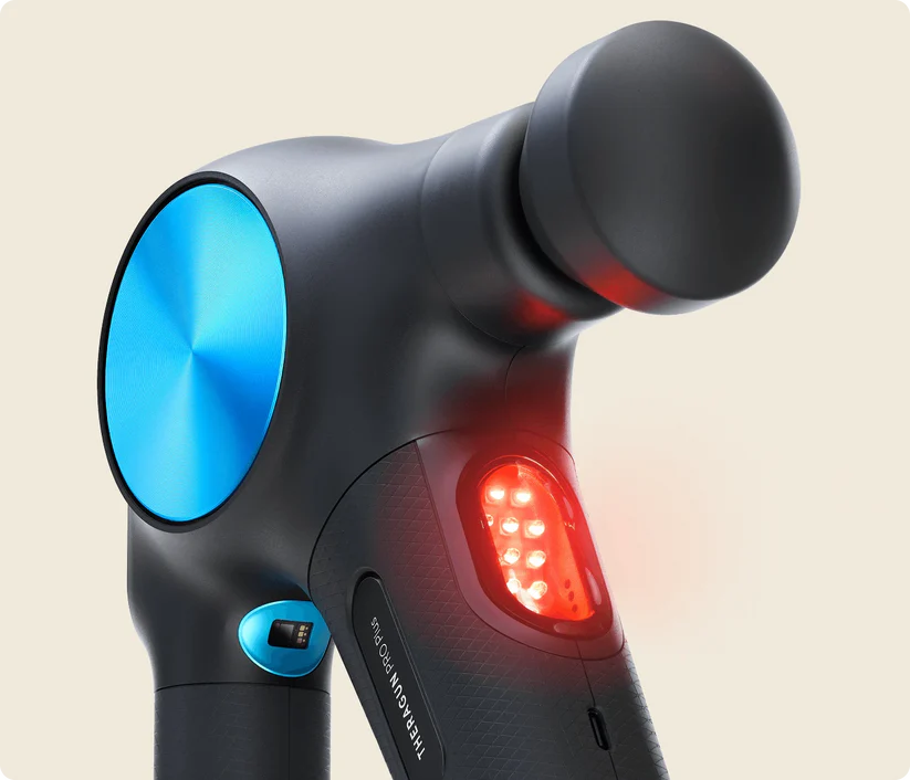 Pistola de masaje negra con elemento circular azul y LEDs rojos. Vista cercana.
