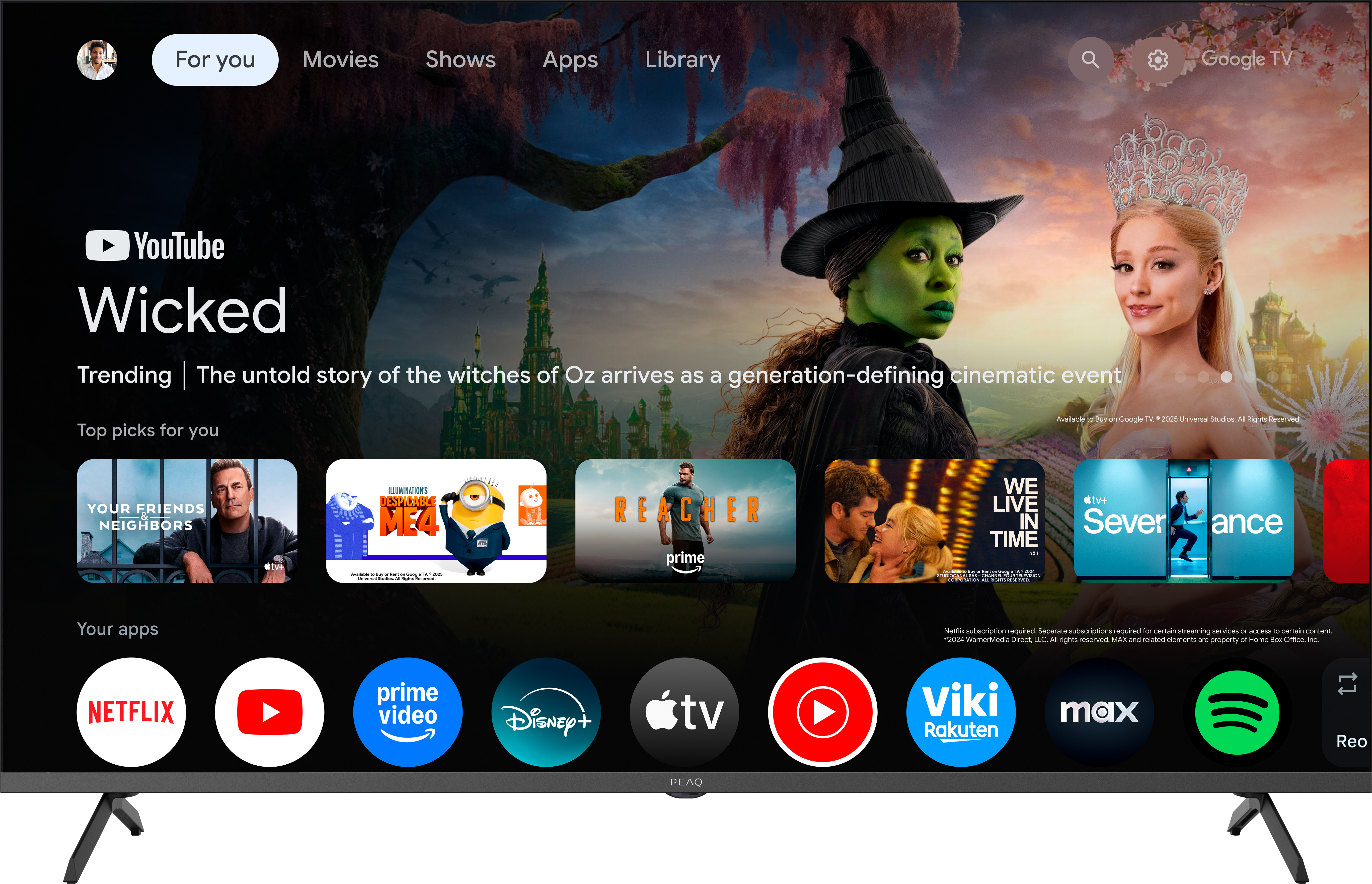 Fernsehbildschirm zeigt „Wicked“ mit grüner Hexe und Prinzessin. Apps-Reihe darunter.