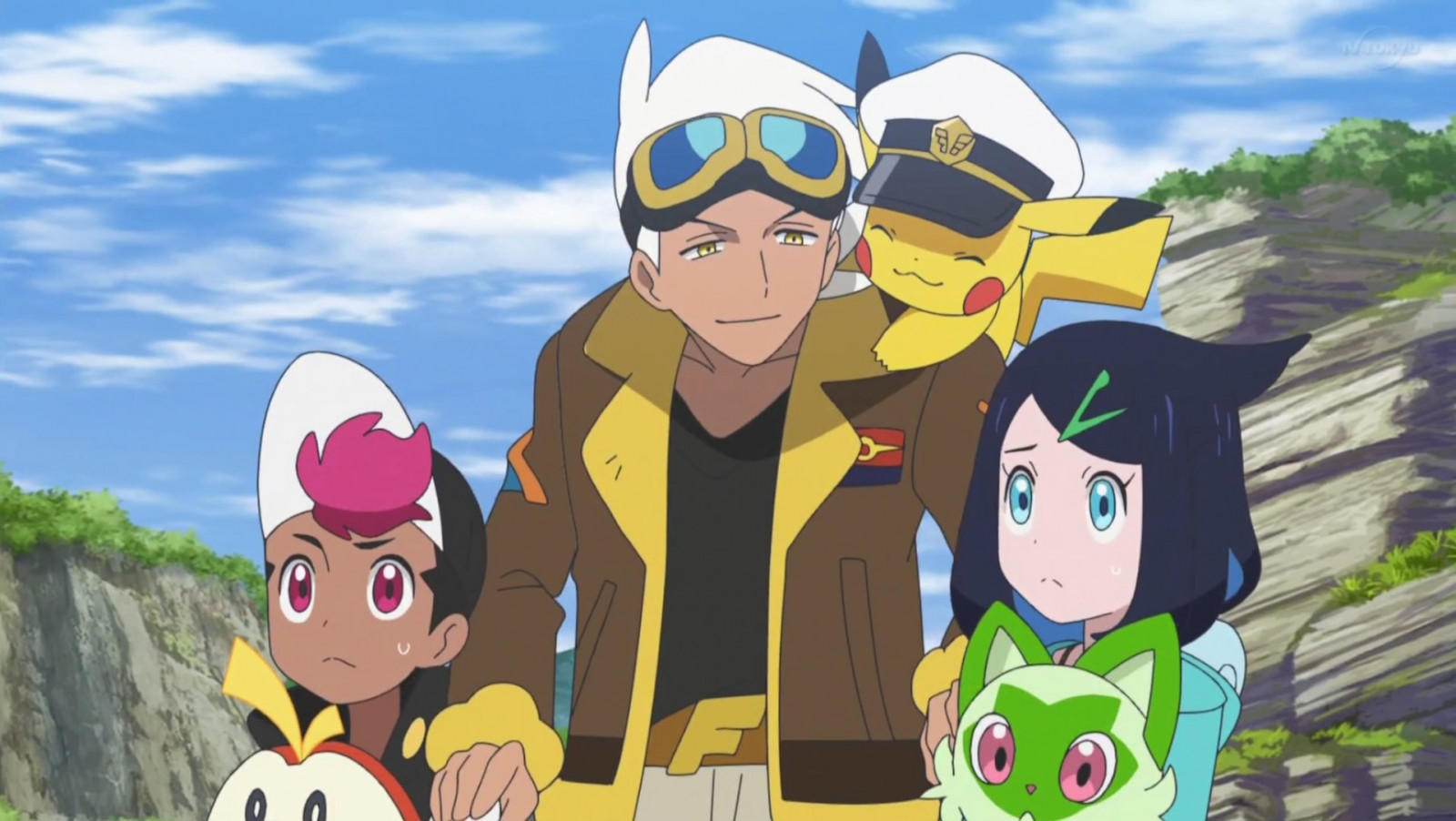Menschen und Pokémon stehen auf einer felsigen Anhöhe unter blauem Himmel.