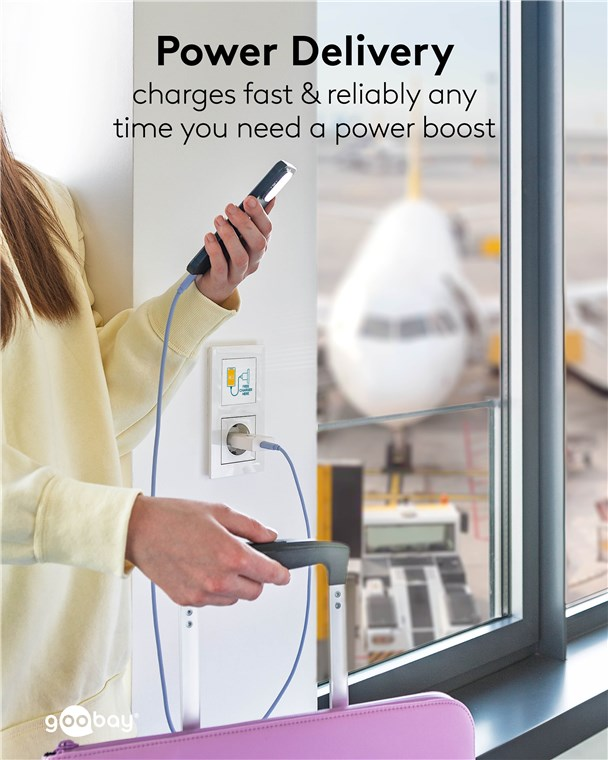 Person lädt Handy am Flughafen, Flugzeug im Hintergrund.