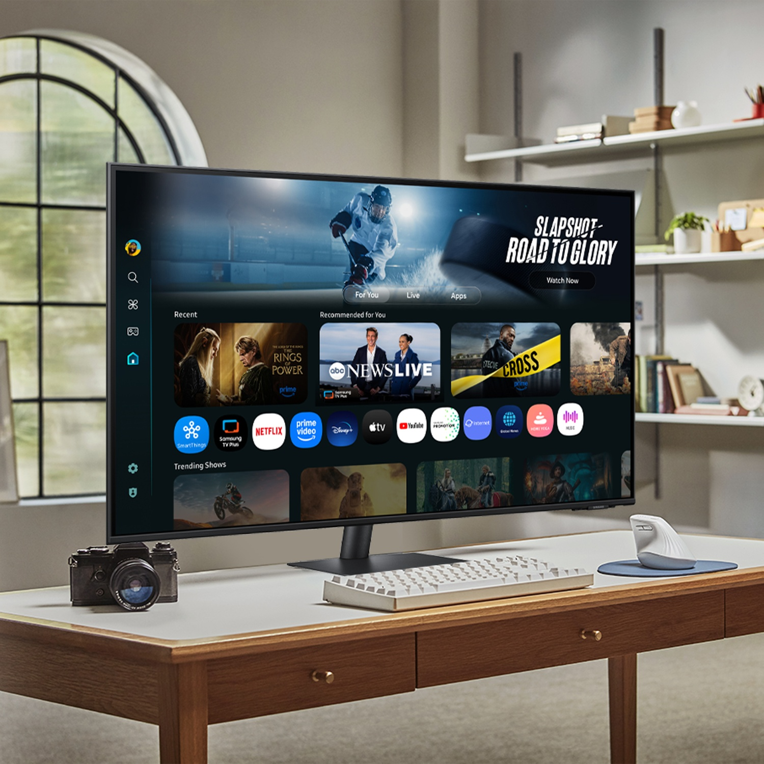 Un monitor moderno su una scrivania con tastiera e mouse.