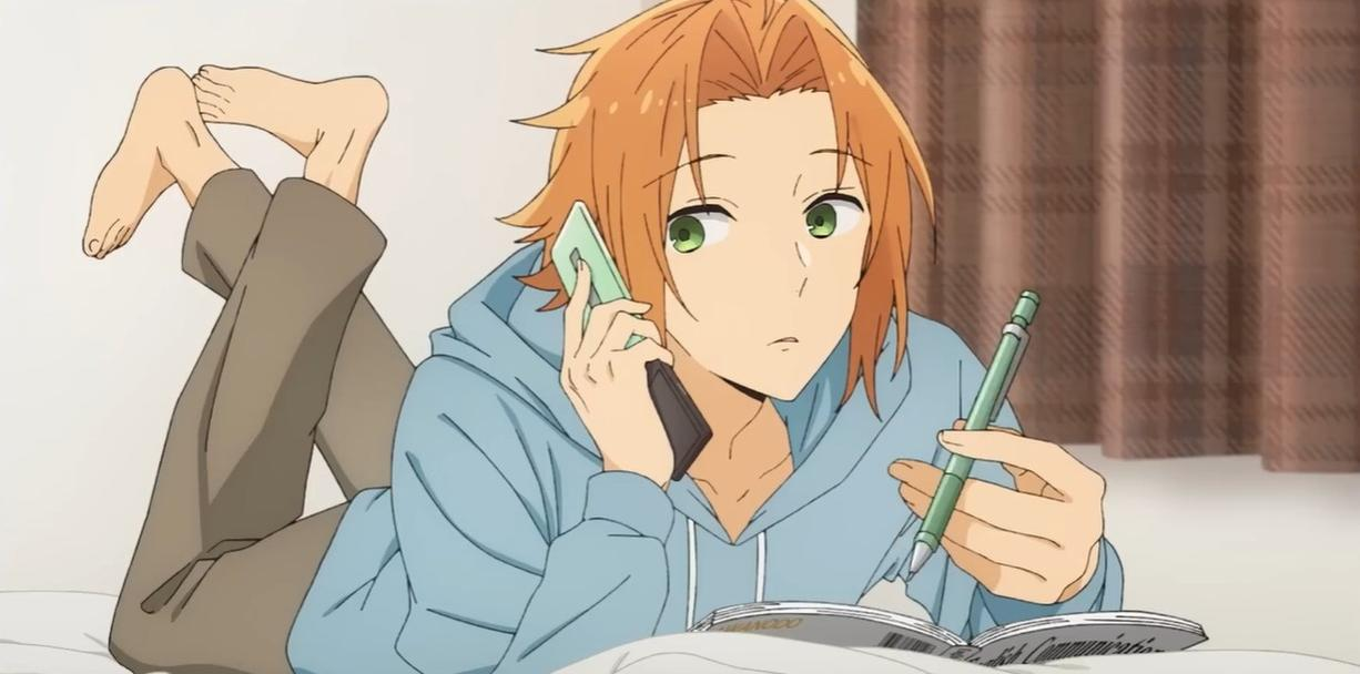 Ein Junge mit orangenem Haar telefoniert und schreibt in einem Notizbuch.