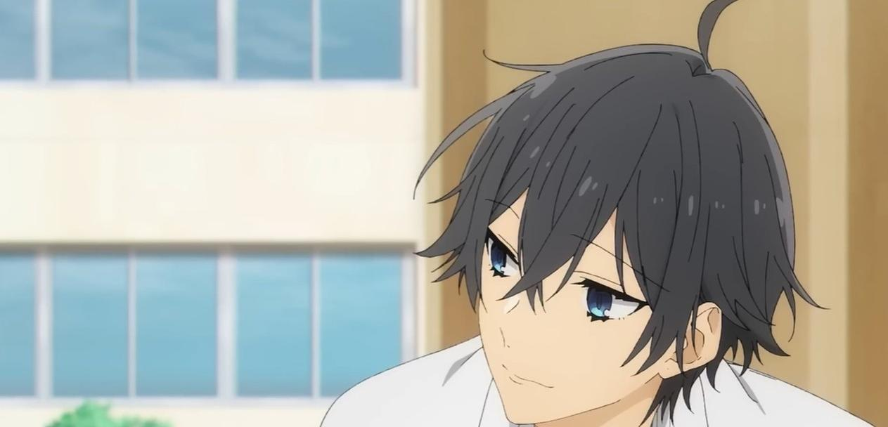 Ein Anime-Junge mit dunklem Haar und blauen Augen blickt zur Seite.