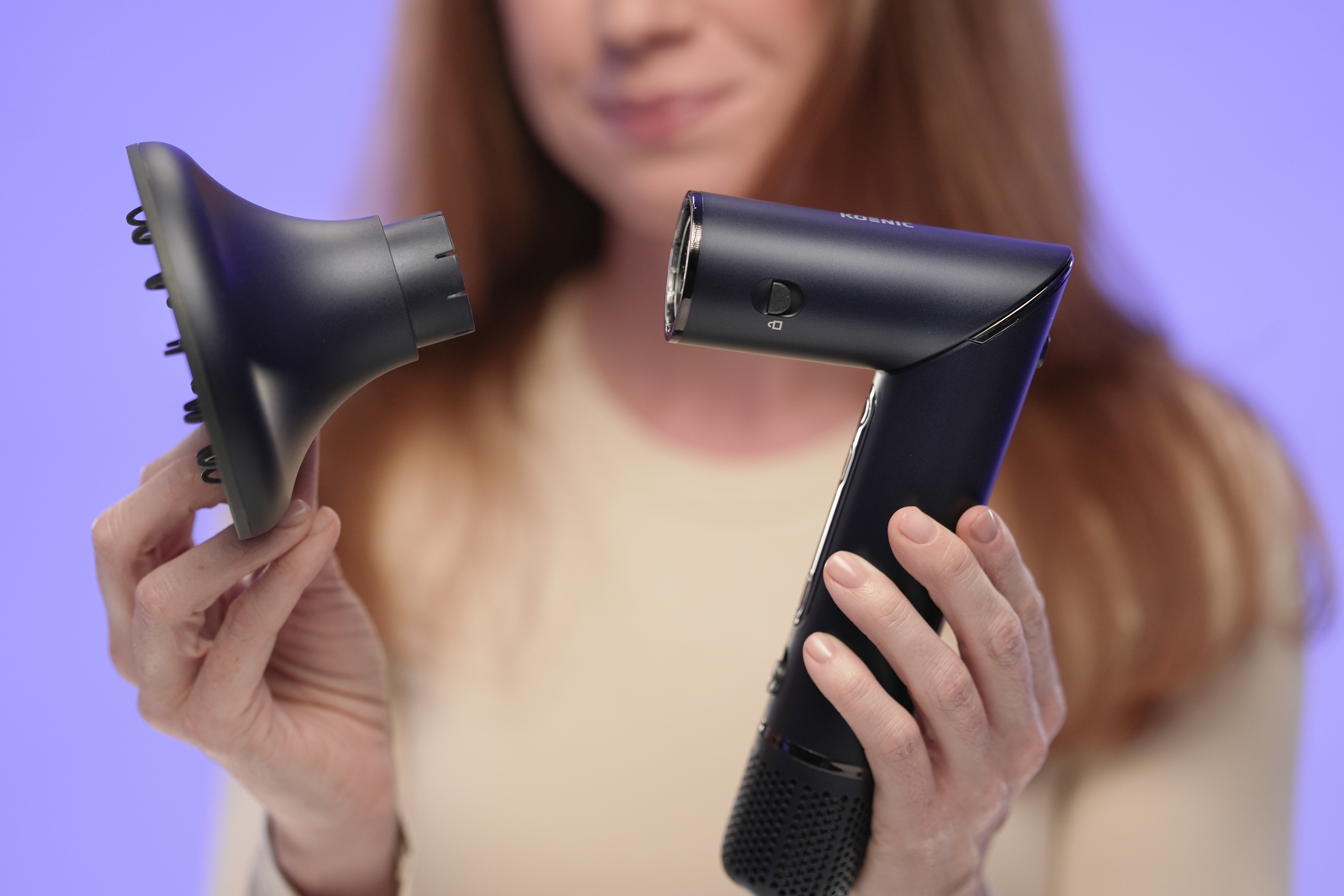 Osoba trzyma czarny dyfuzor do włosów i czarną suszarkę do włosów.