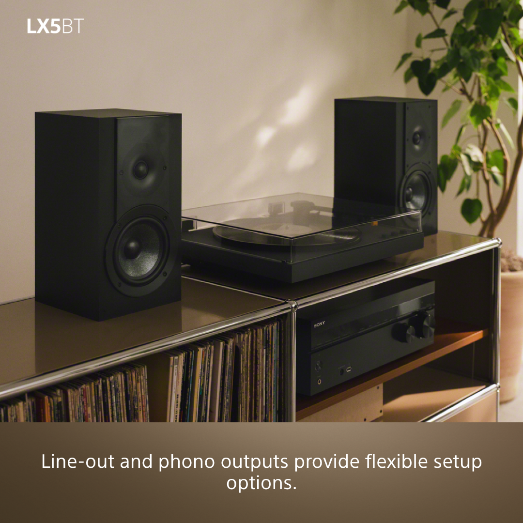 Enceintes et platine vinyle noires sur une étagère avec des disques.