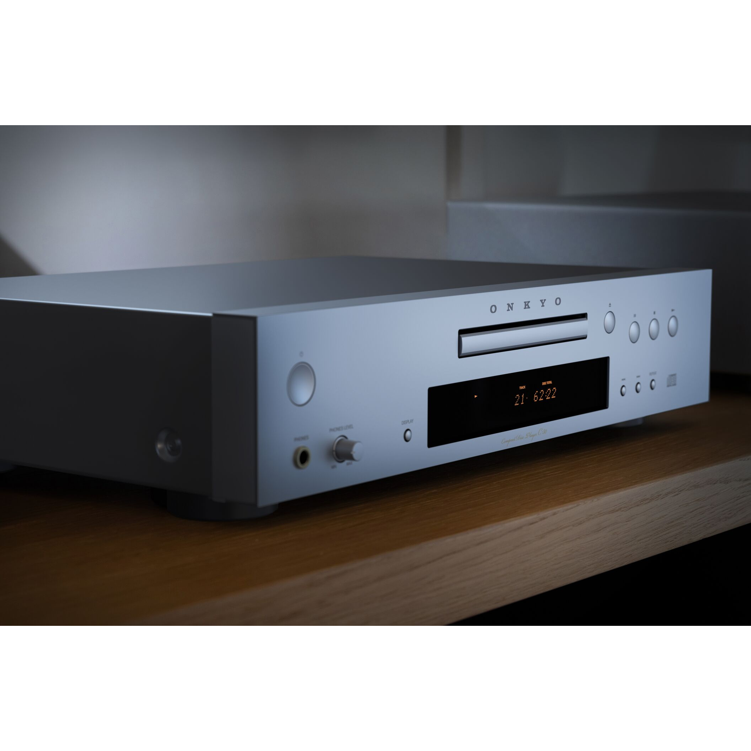 Silver Onkyo CD player with display, buttons, and drawer on wooden surface.