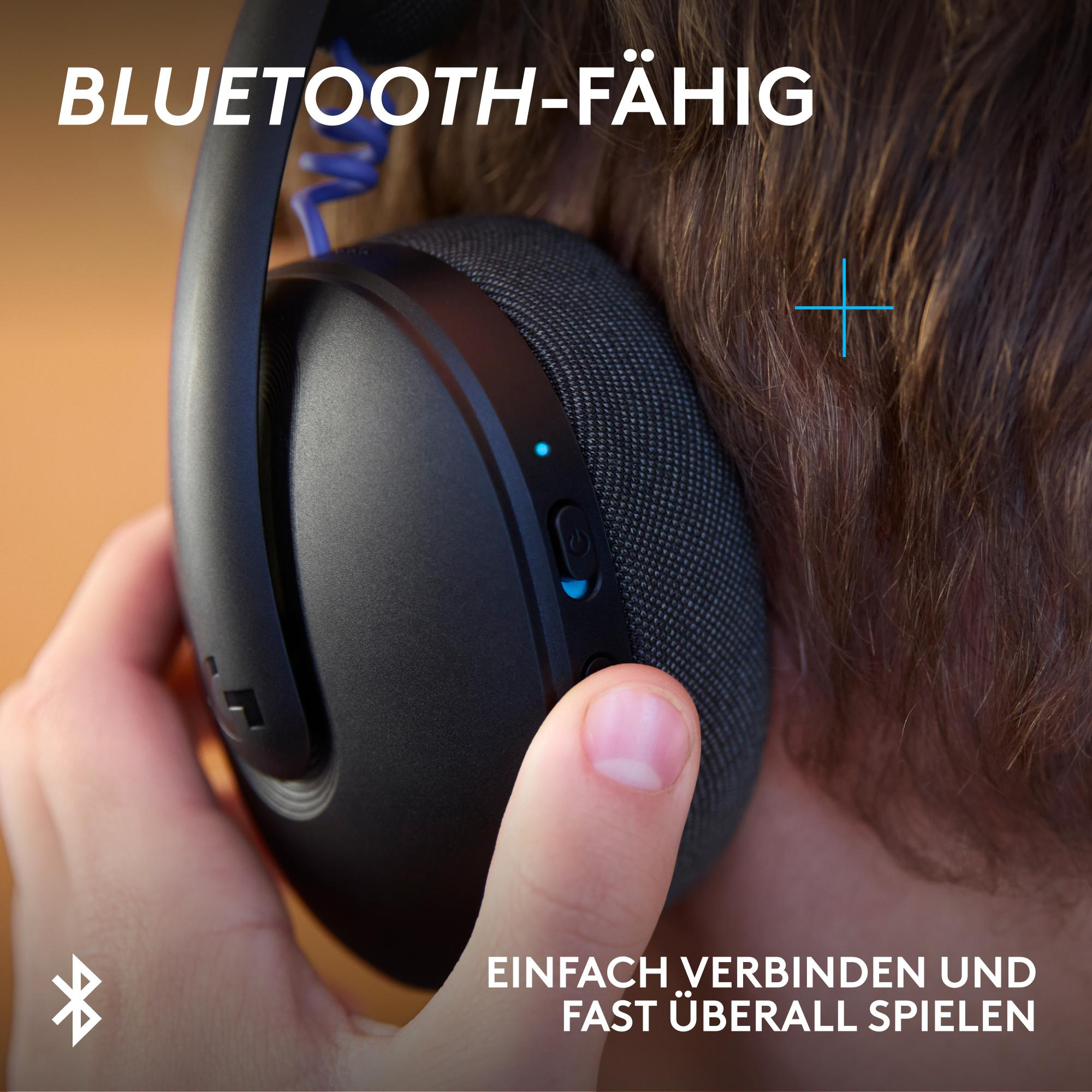 Nahaufnahme von schwarzen Kopfhörern, die mit einem blauen Kabel verbunden sind.