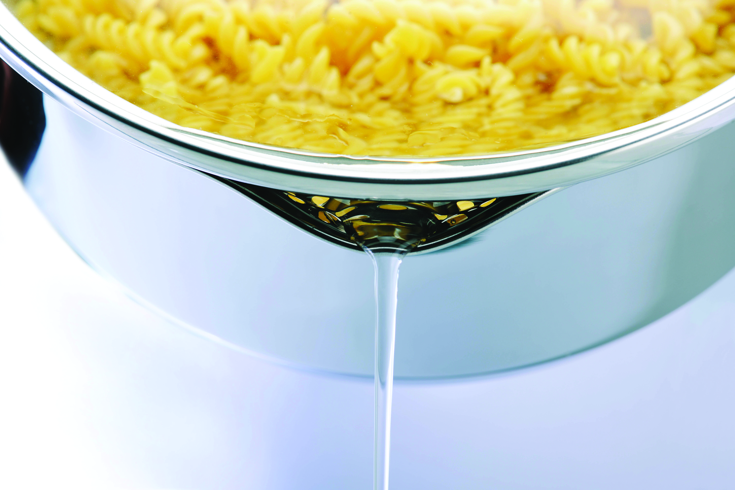 Főtt fusilli tészta lecsöpögtetve egy lábosban, víz folyik ki.