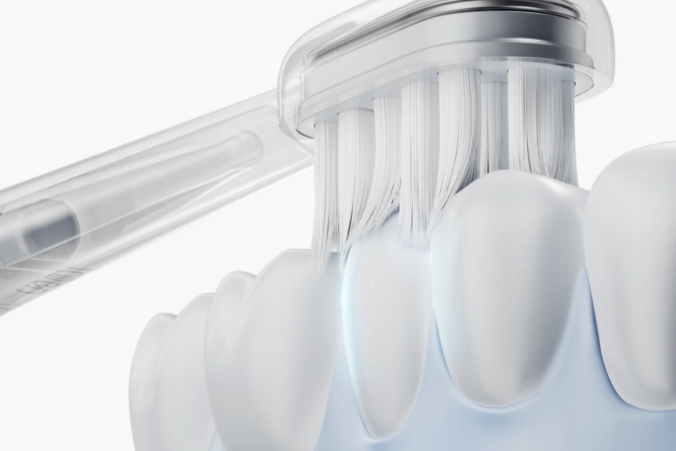 Białe włosie szczoteczki czyści białe zęby na niebieskich dziąsłach.