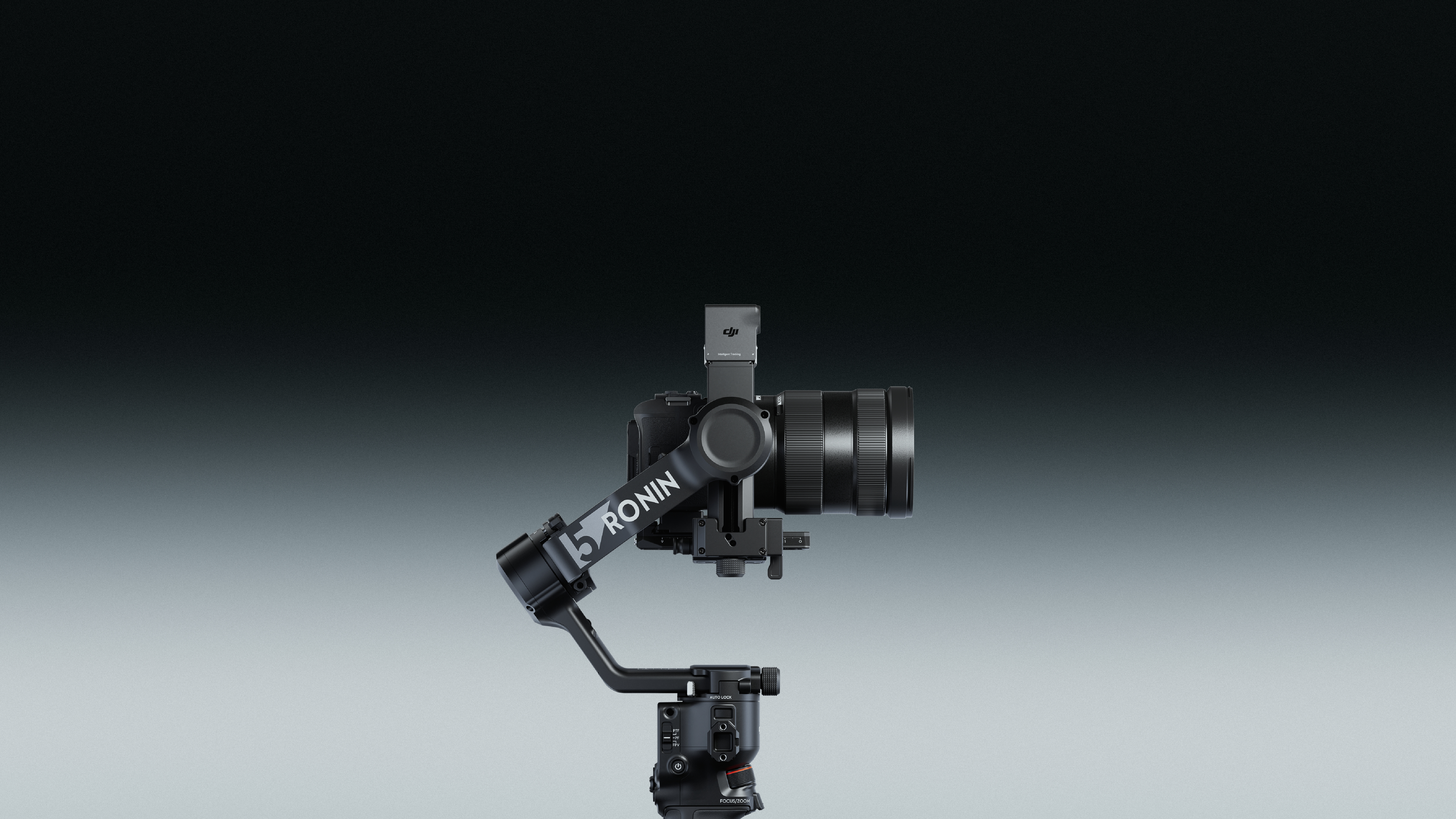 Czarny gimbal do kamery z zamontowaną kamerą i obiektywem na szarym tle z gradientem.