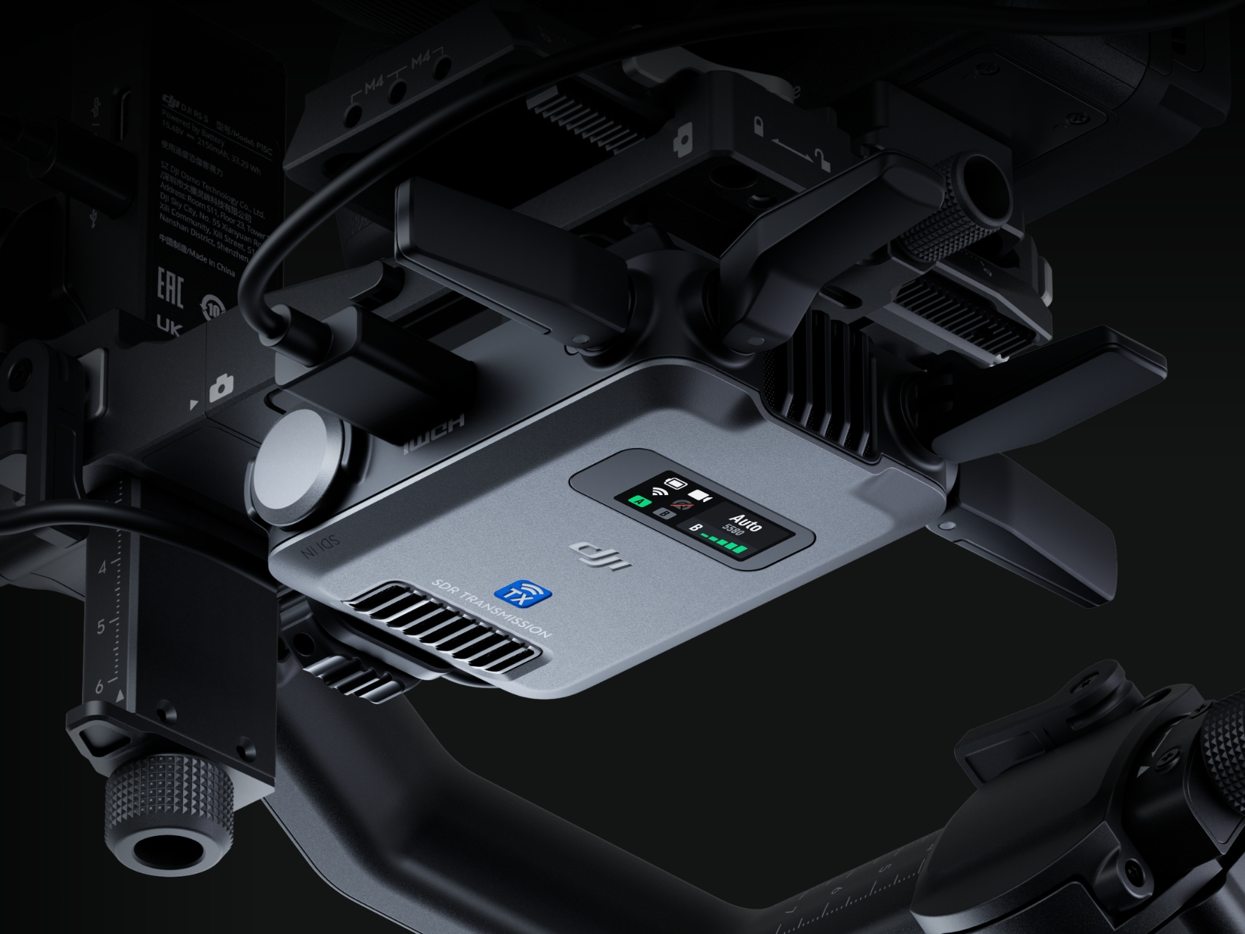 Jednostka transmisyjna DJI SDR na stabilizatorze. Ekran pokazuje Auto 5580, siłę sygnału.