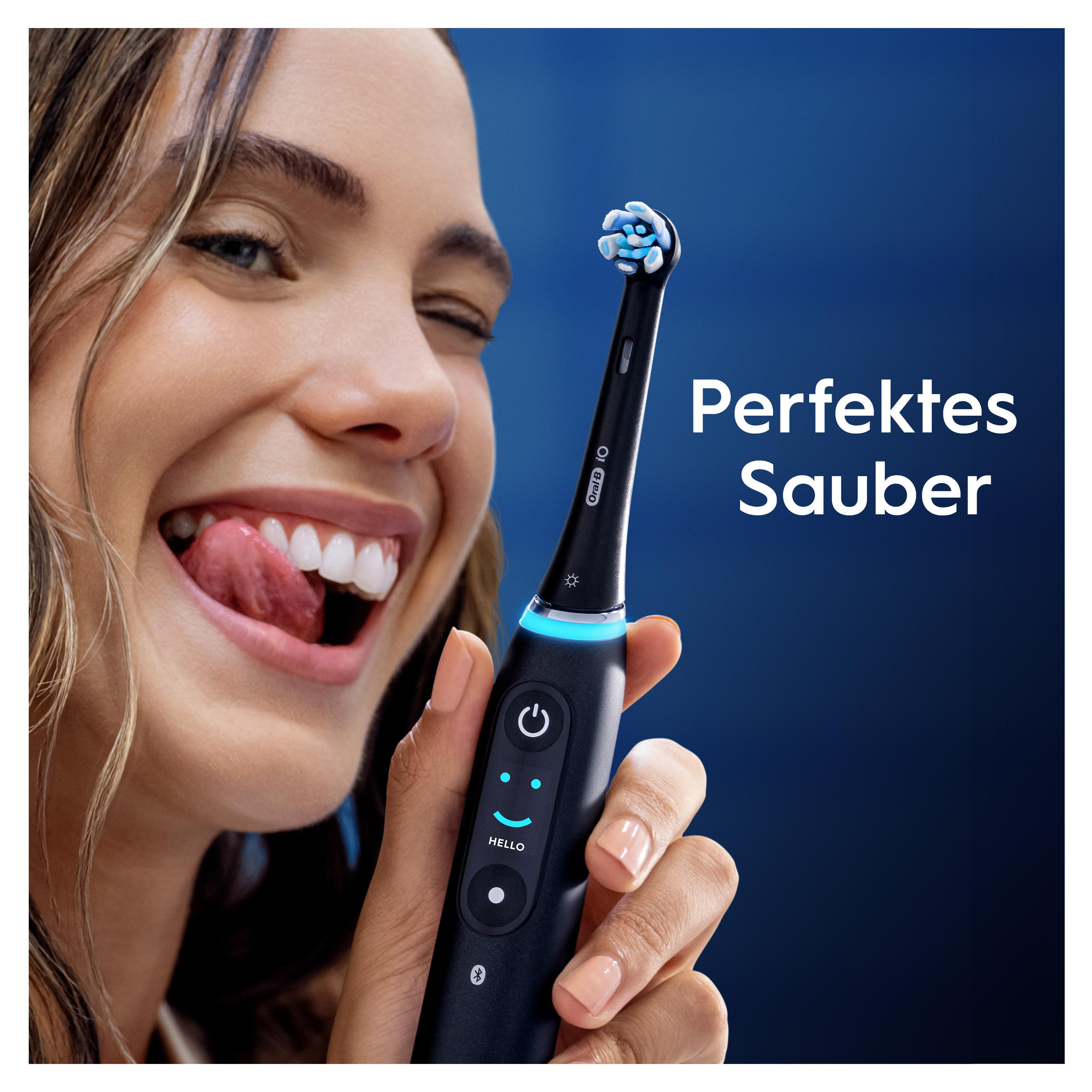 Frau leckt sich die Lippen, hält Oral-B iO Zahnbürste mit blauem Licht.