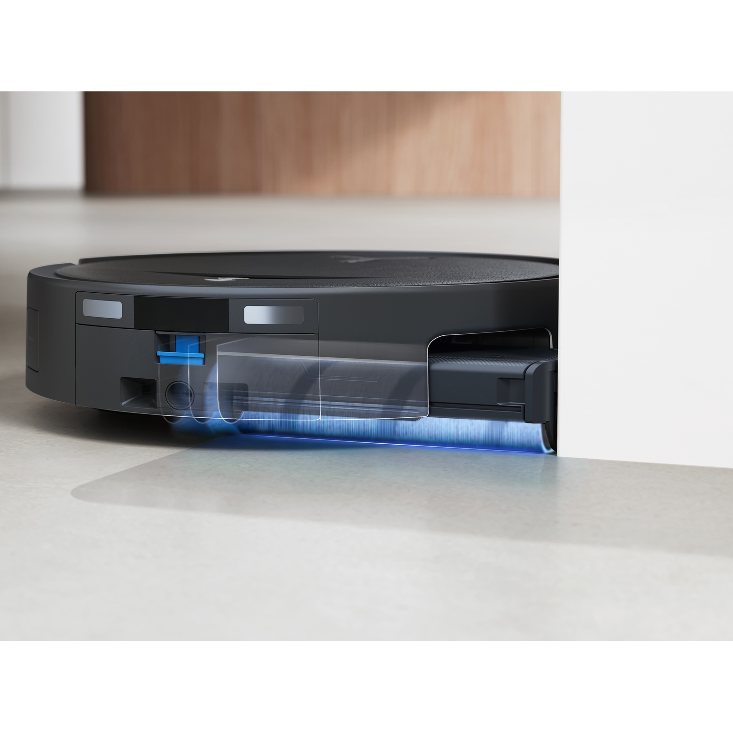 Un robot aspirapolvere nero su un pavimento chiaro con indicatore di potenza di aspirazione blu.