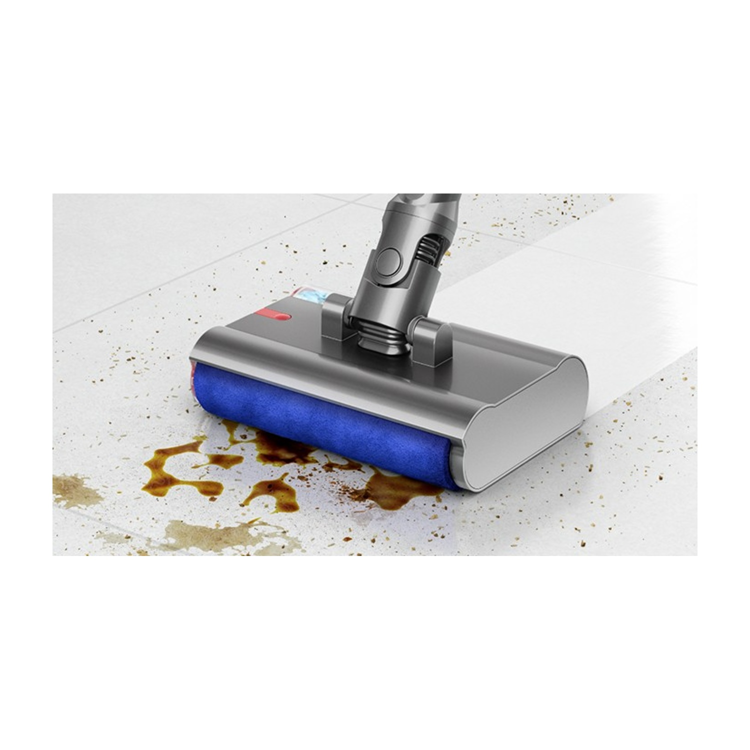 Testina aspirapolvere con rullo blu pulisce versamenti su pavimento chiaro.