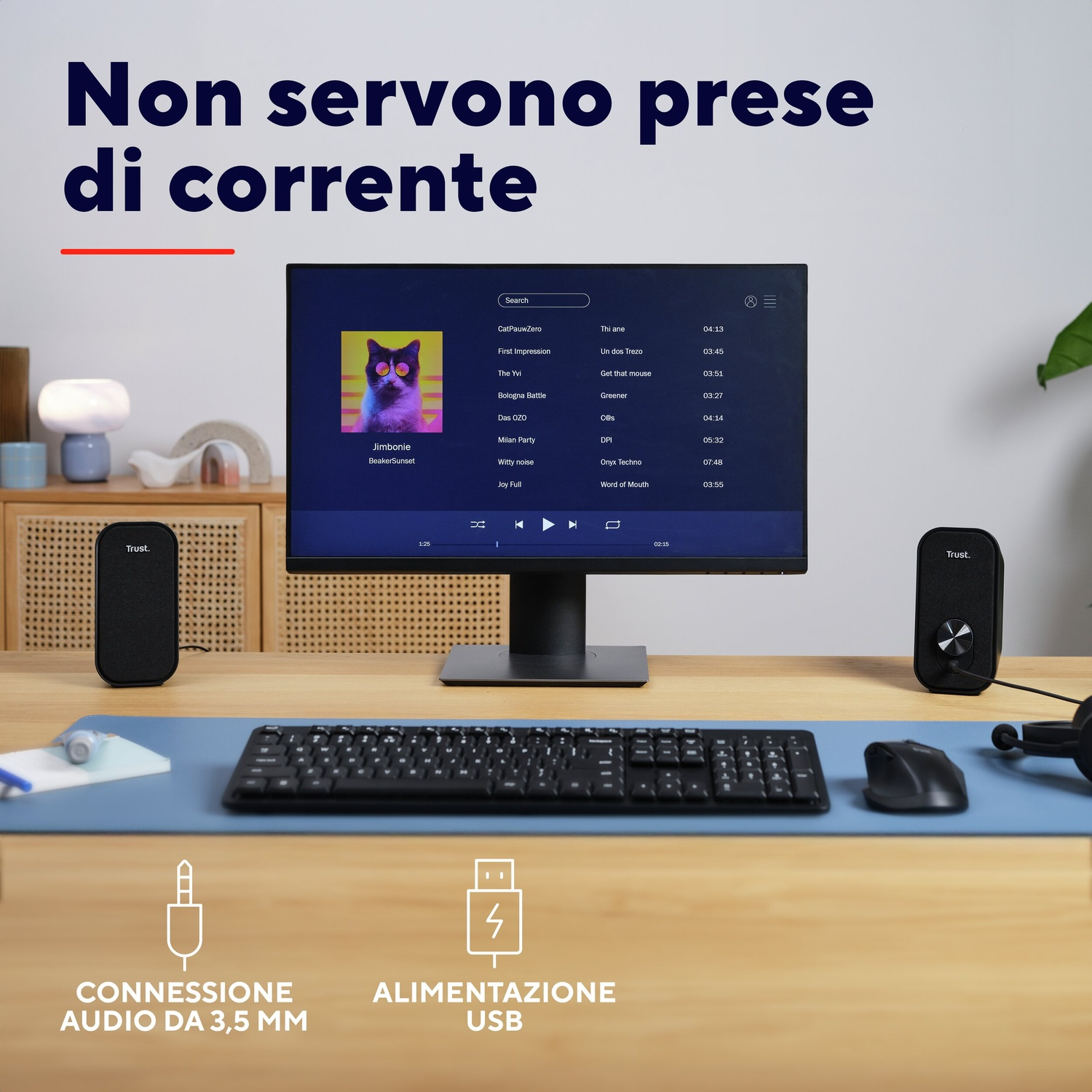 Una scrivania con monitor, tastiera, mouse, altoparlanti e cuffie.