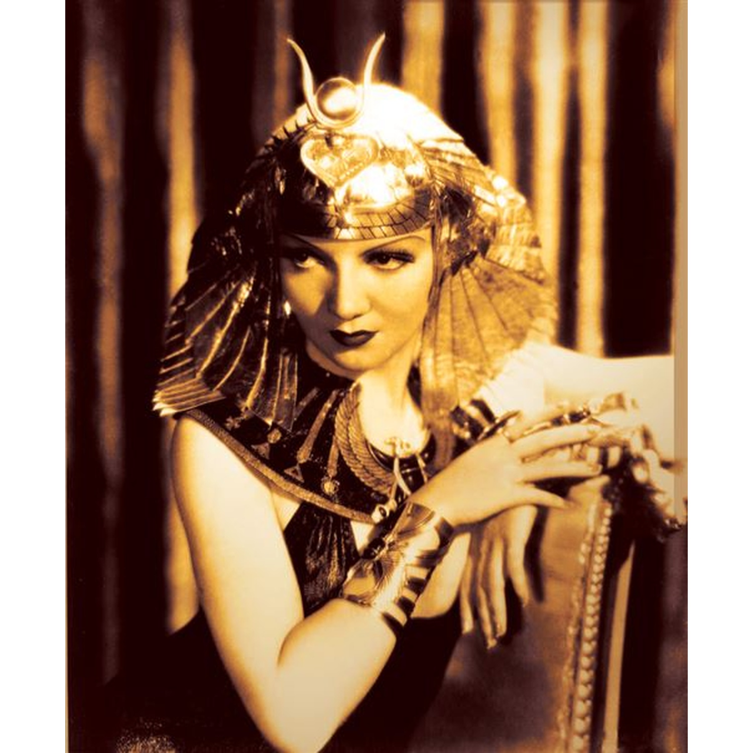 Une femme en tenue égyptienne avec coiffe et collier dorés.