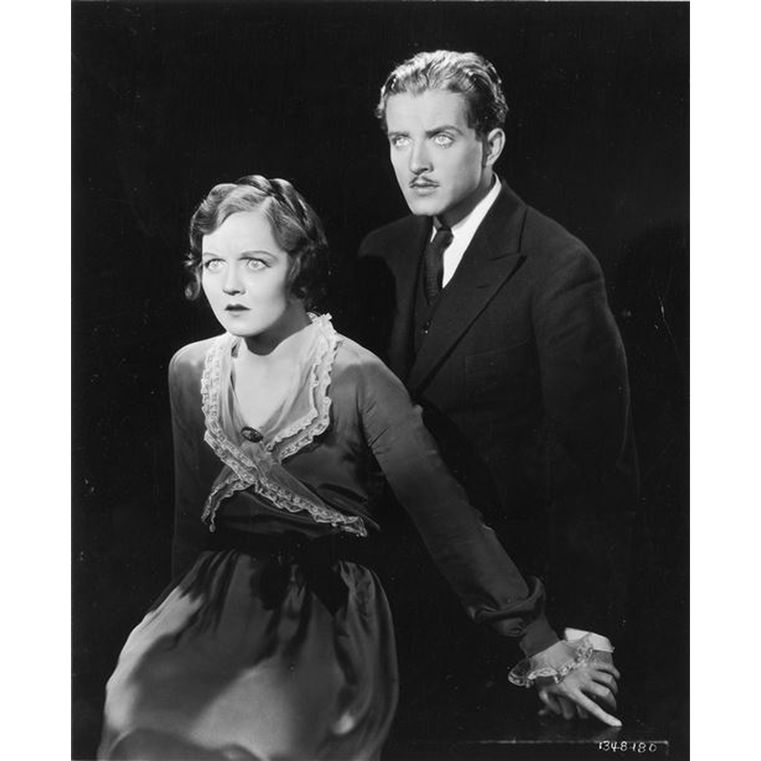 Un homme et une femme aux expressions dramatiques se tiennent près.