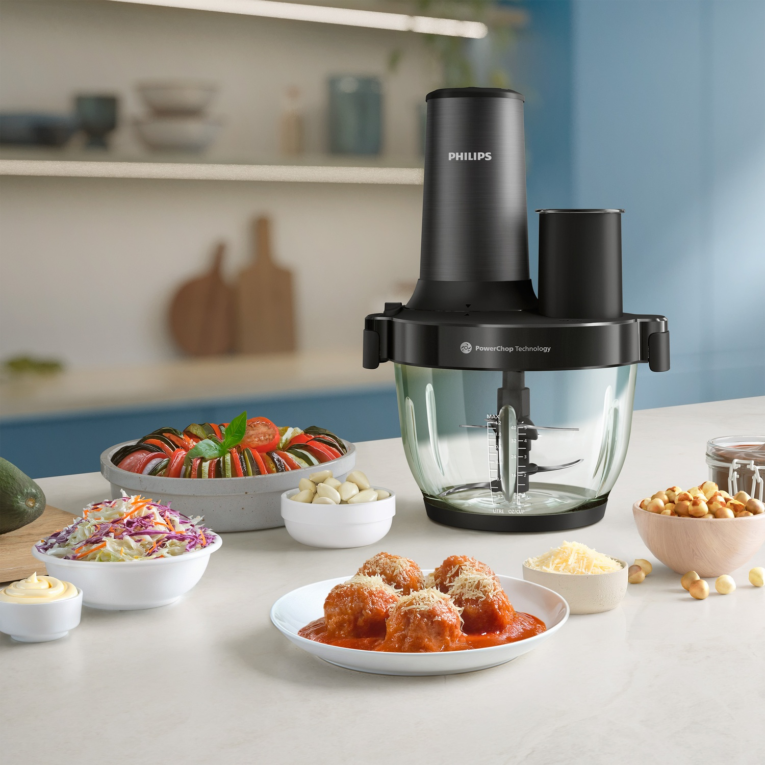 Un robot culinaire Philips à côté de plats comme des boulettes de viande et ratatouille.