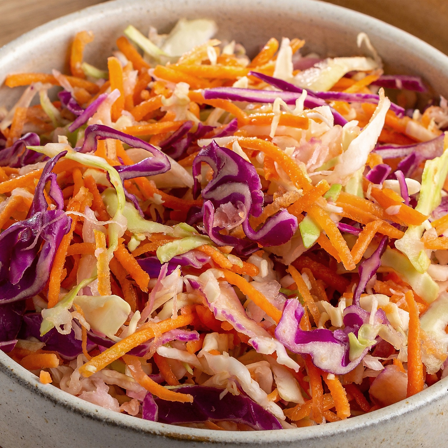 Gros plan de salade de chou avec carottes et chou rouge dans un bol.