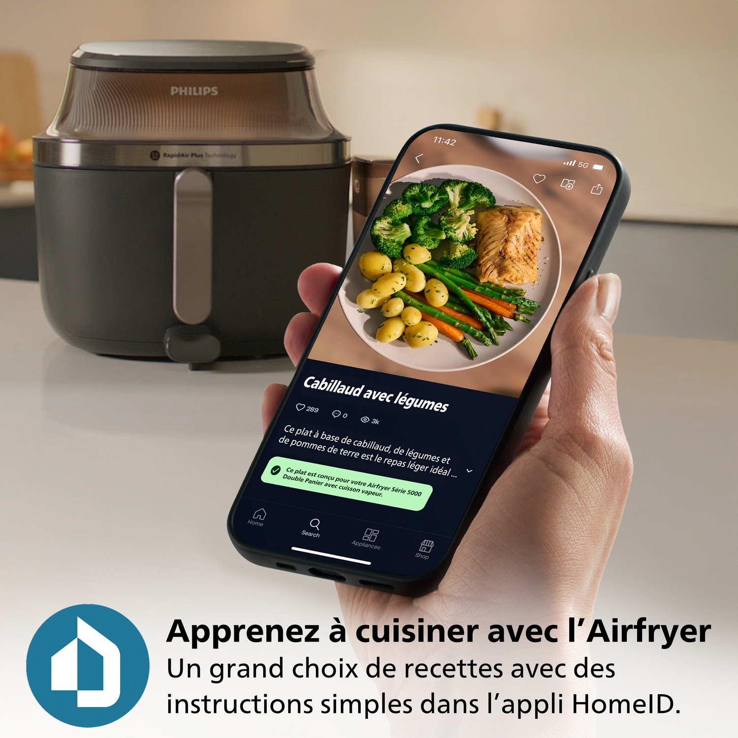 Un Airfryer et un smartphone affichant une recette de poisson avec légumes.