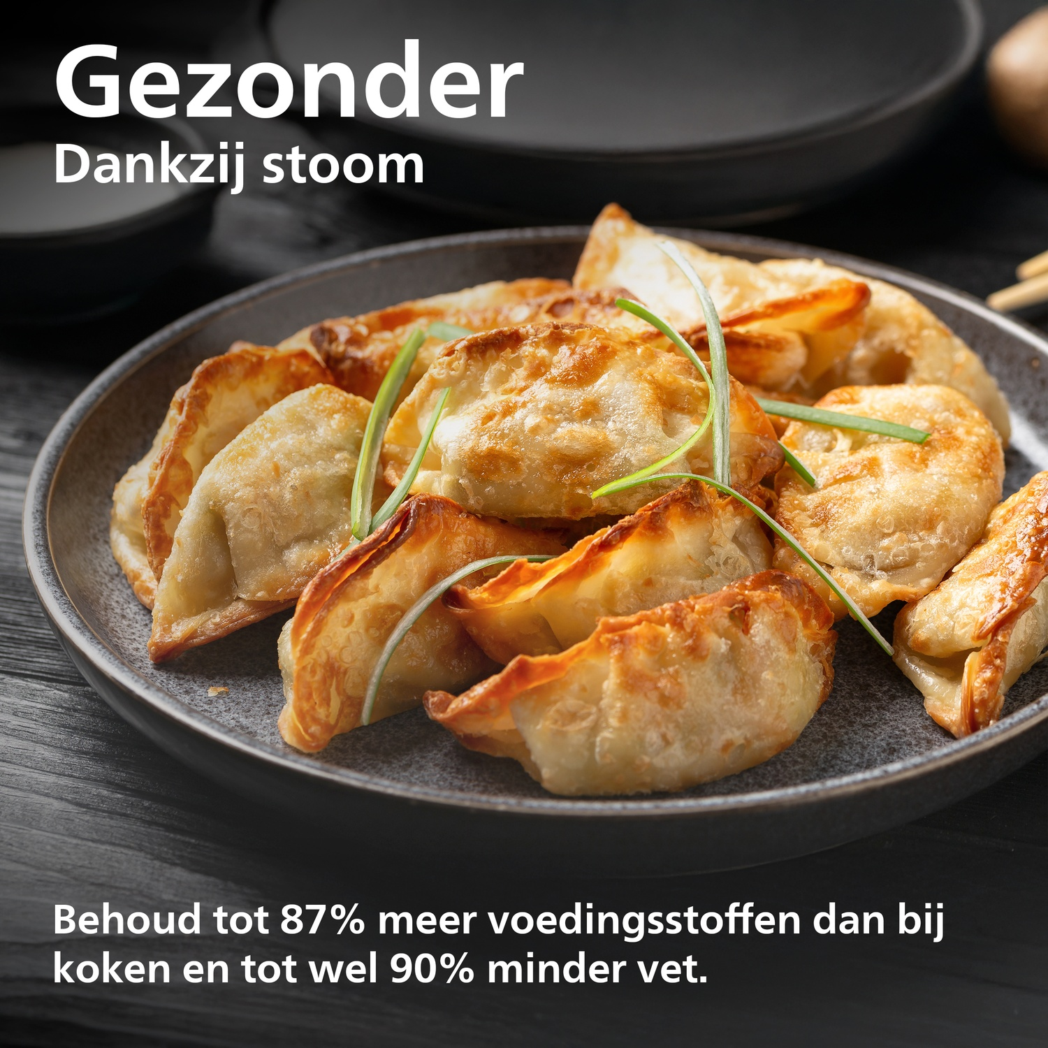 Steamed dumplings on a plate, garnished with green onions.