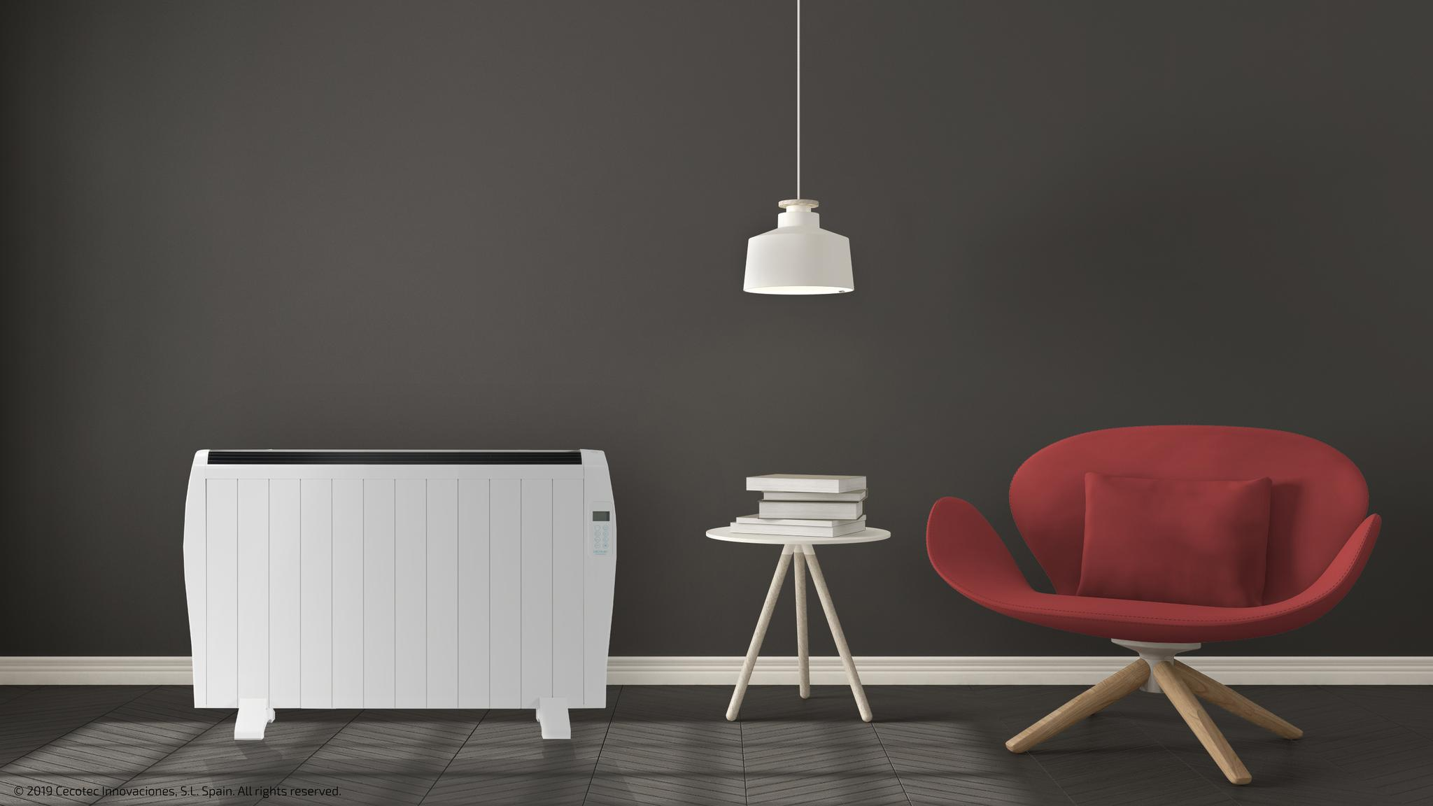 Un radiador blanco, una mesa pequeña con libros y un sillón rojo.