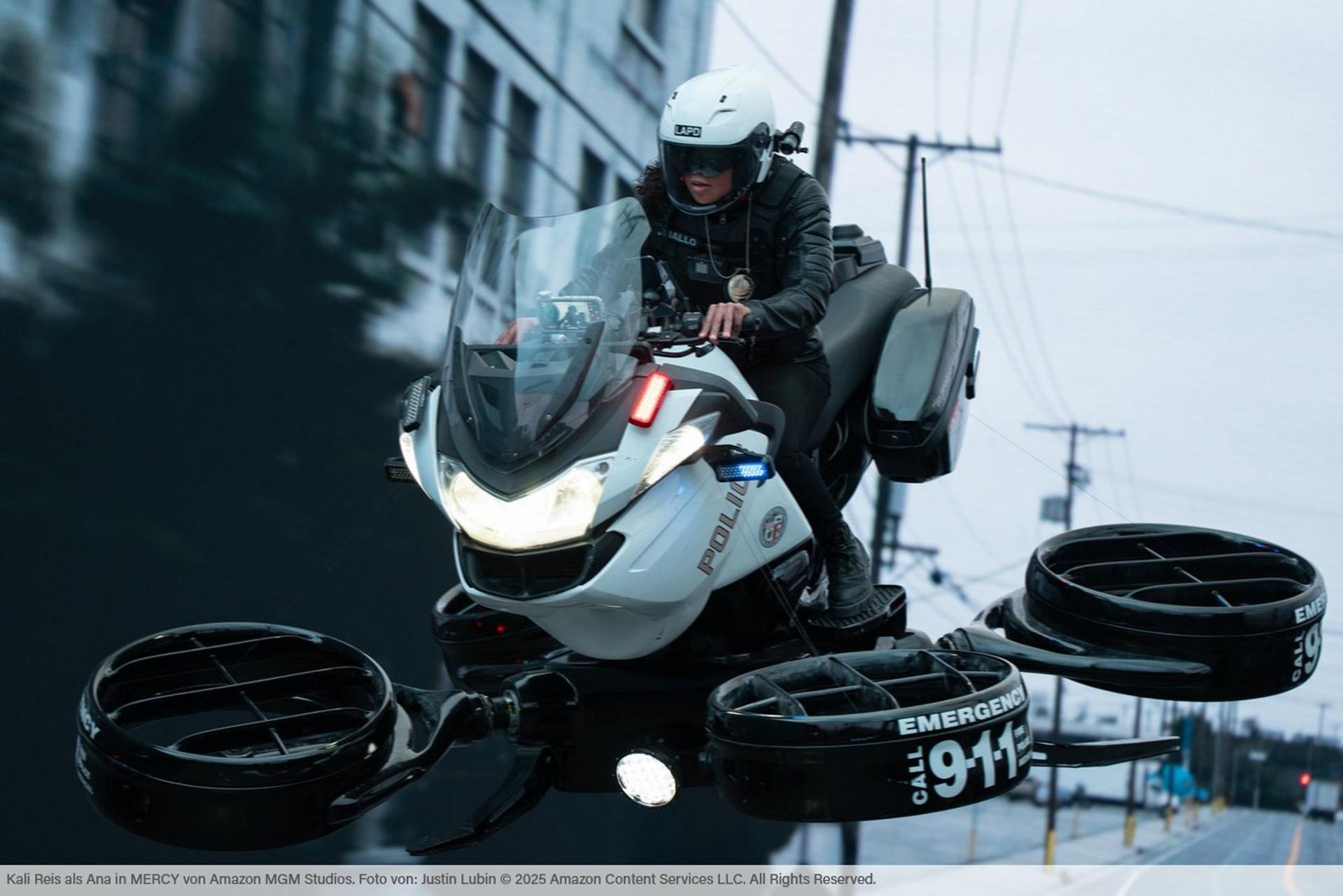 Eine Polizistin auf einem fliegenden Motorrad mit Propellern fliegt tagsüber.