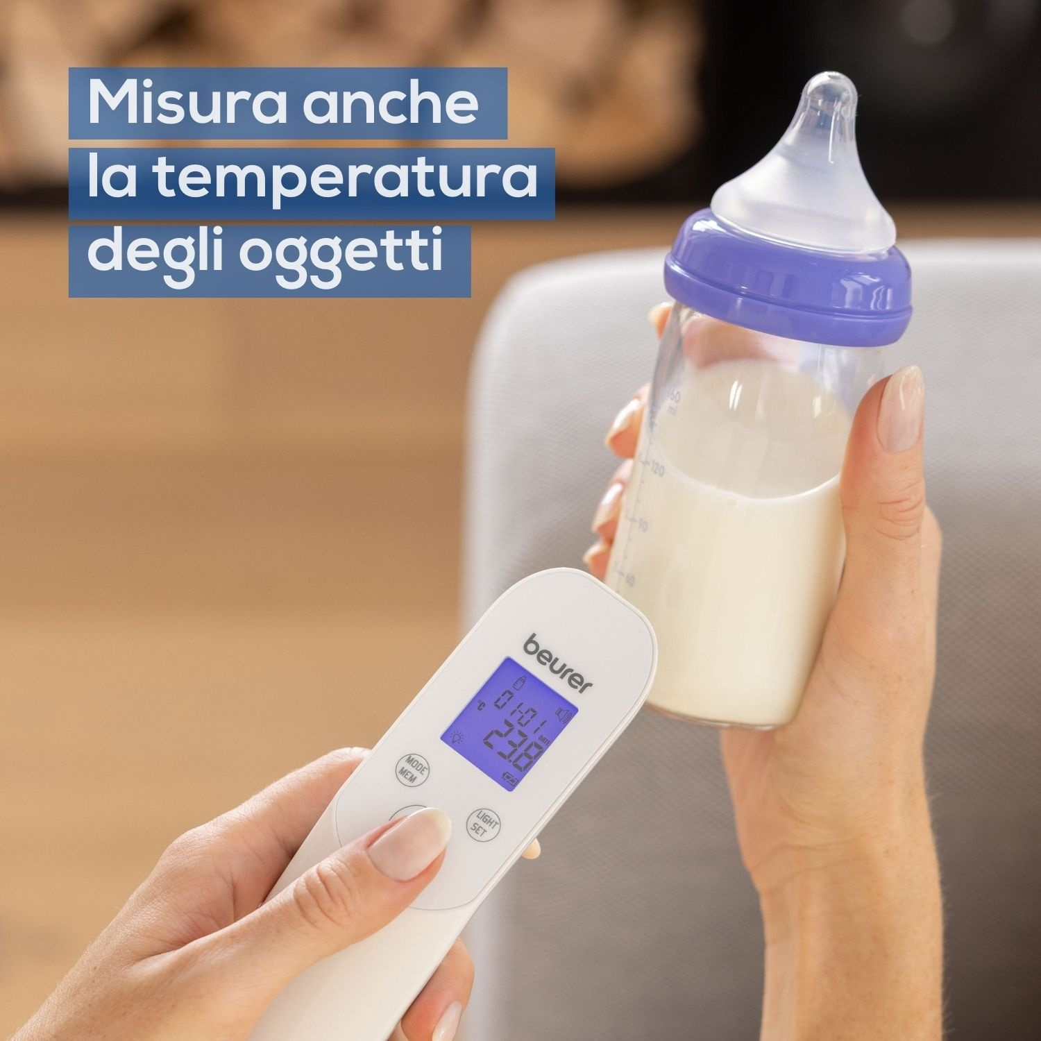 Una mano tiene un termometro, misurando la temperatura di un biberon.