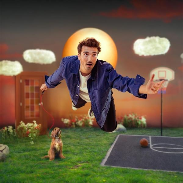 Homme vole avec chien en laisse au-dessus d'un terrain de basket devant grand soleil.