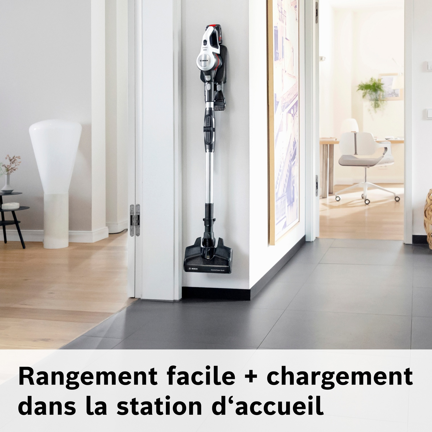 Un aspirateur sans fil Bosch monté sur un support mural dans un couloir.