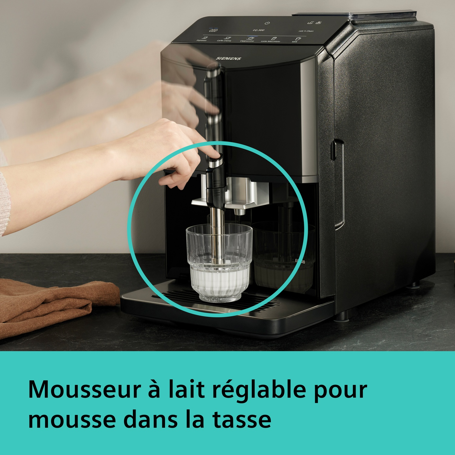 Une main actionne une machine à café qui fait mousser du lait dans un verre.