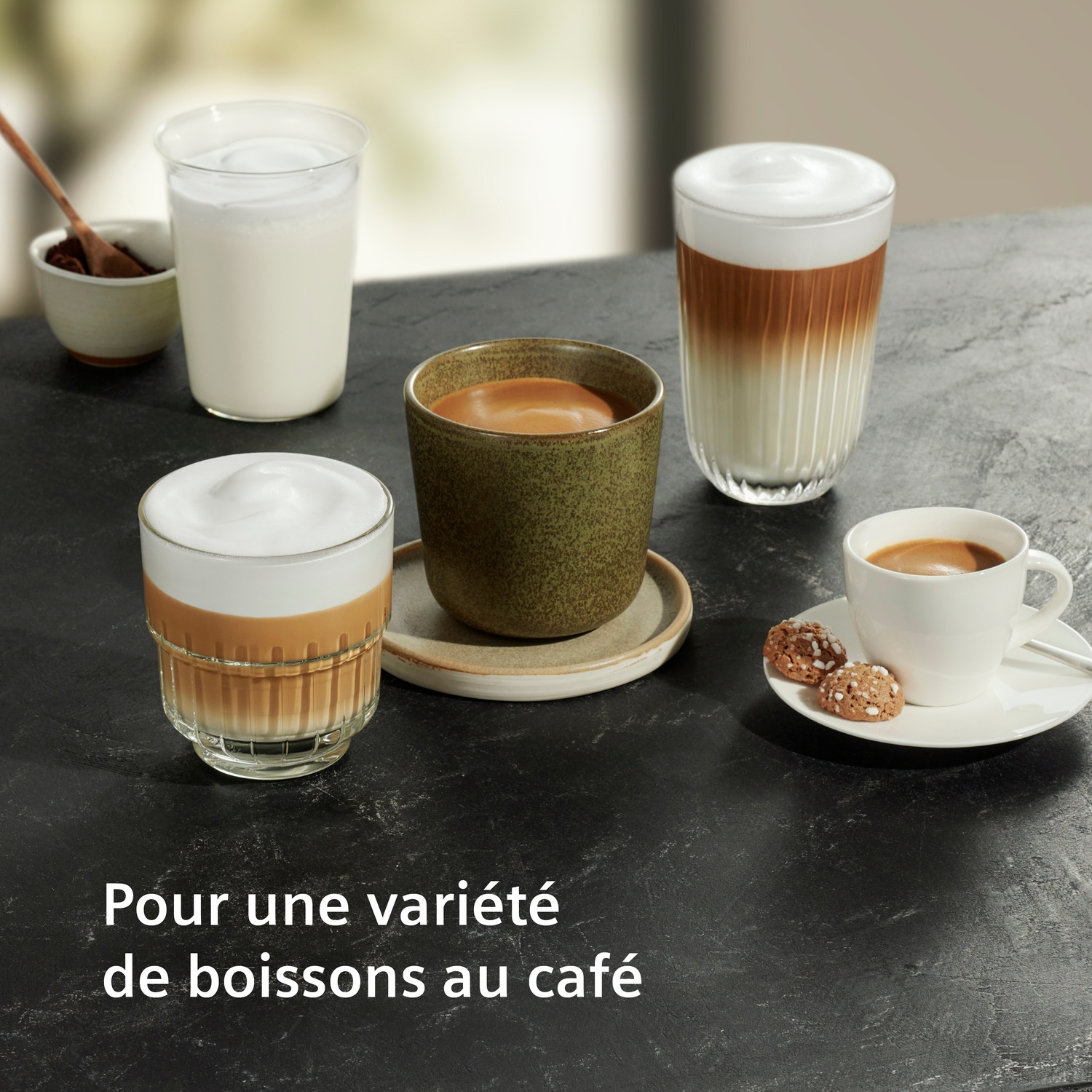 Boissons au café avec mousse de lait et biscuits sur table sombre.