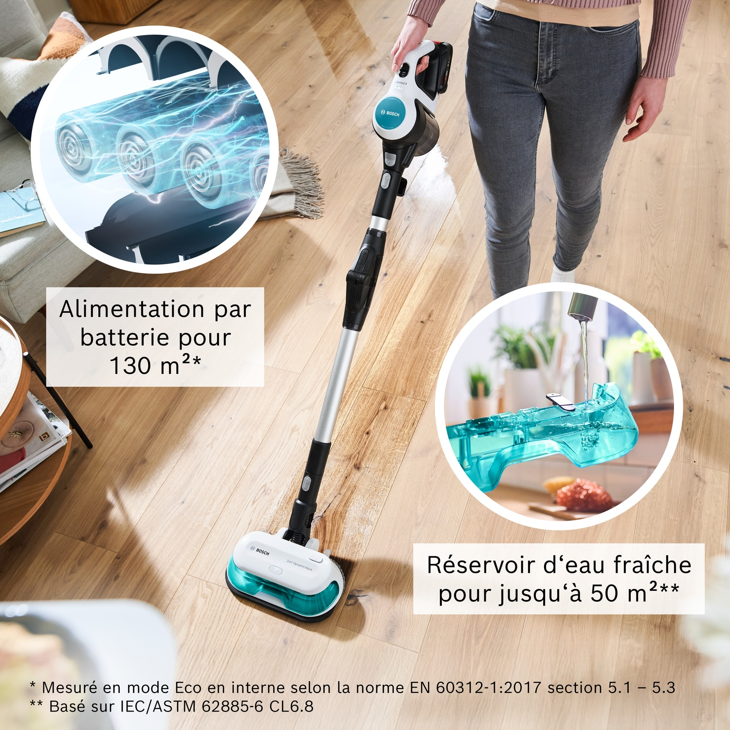 Un aspirateur sans fil avec réservoir d'eau est utilisé par une personne sur un parquet.