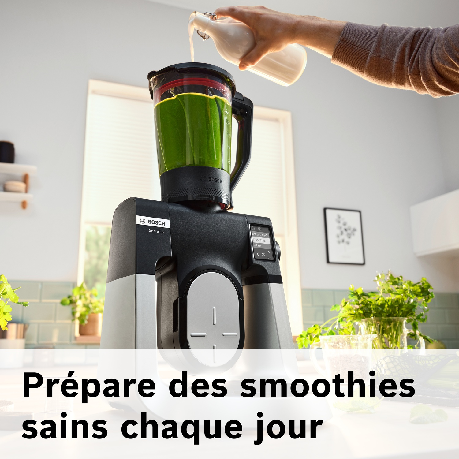 Une personne verse du liquide dans un mixeur avec un smoothie vert.