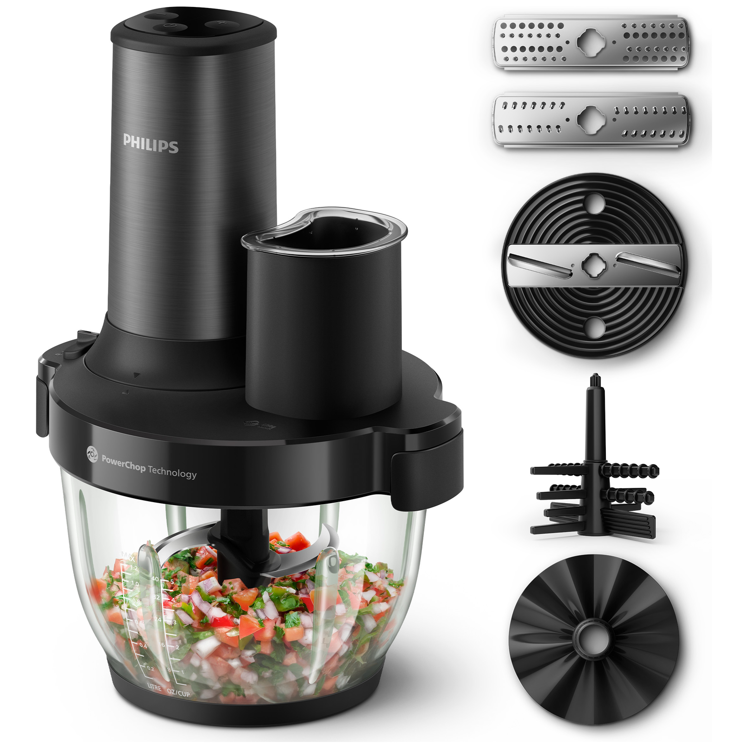 Black Philips food processor with chopped vegetables. Accessories are beside it.