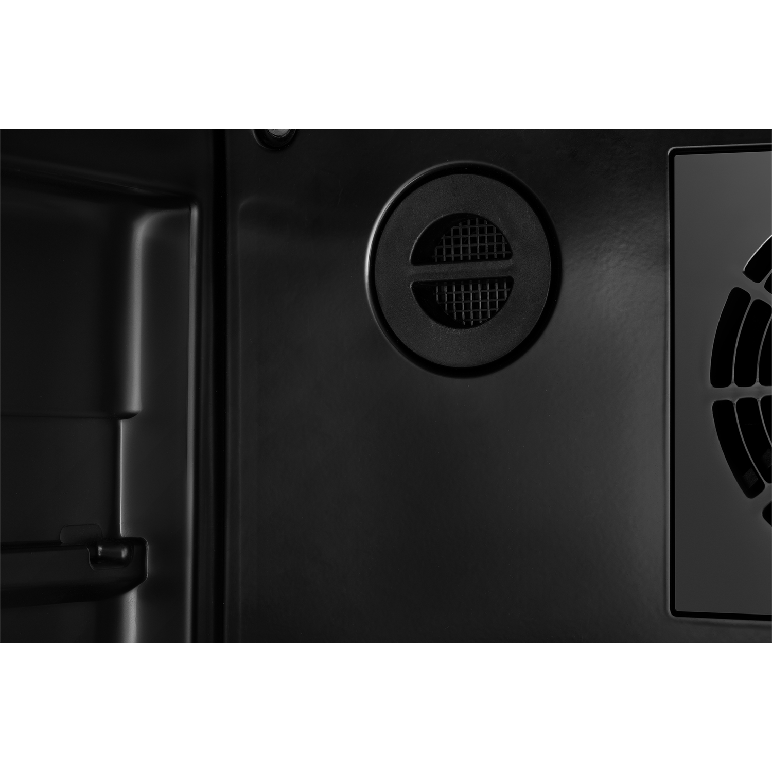 Black interior with a vent grille and fan.