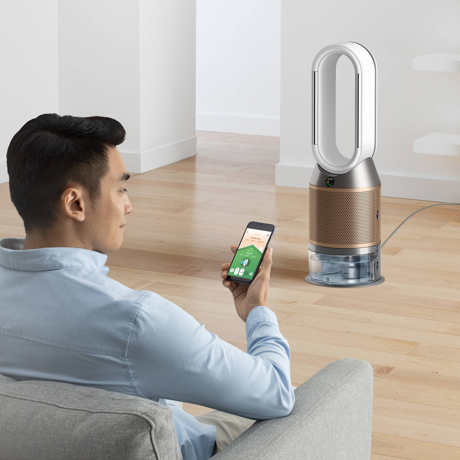 Uomo su divano usa telefono per controllare purificatore d'aria. Pavimento in legno.