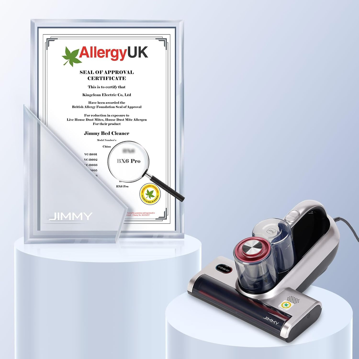 Un pulitore per letti Jimmy e un certificato Allergy UK sono esposti su un piedistallo bianco.