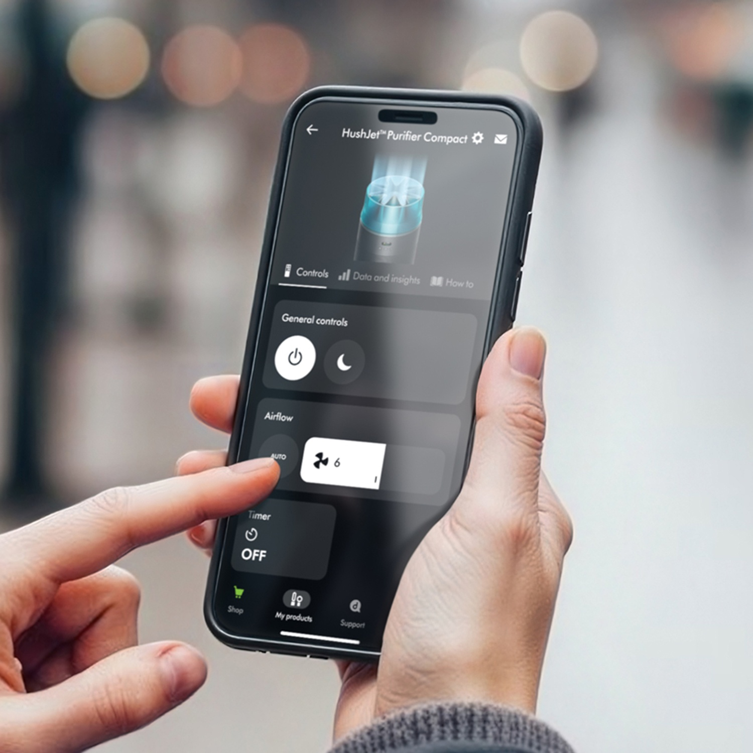 Una mano gestisce un'app di controllo del purificatore d'aria su uno smartphone.