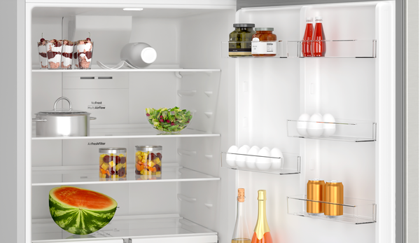 Açık buzdolabı yiyeceklerle: tatlılar, salata, kavanozlar, tencere, karpuz, yumurta, şişeler, kutular.