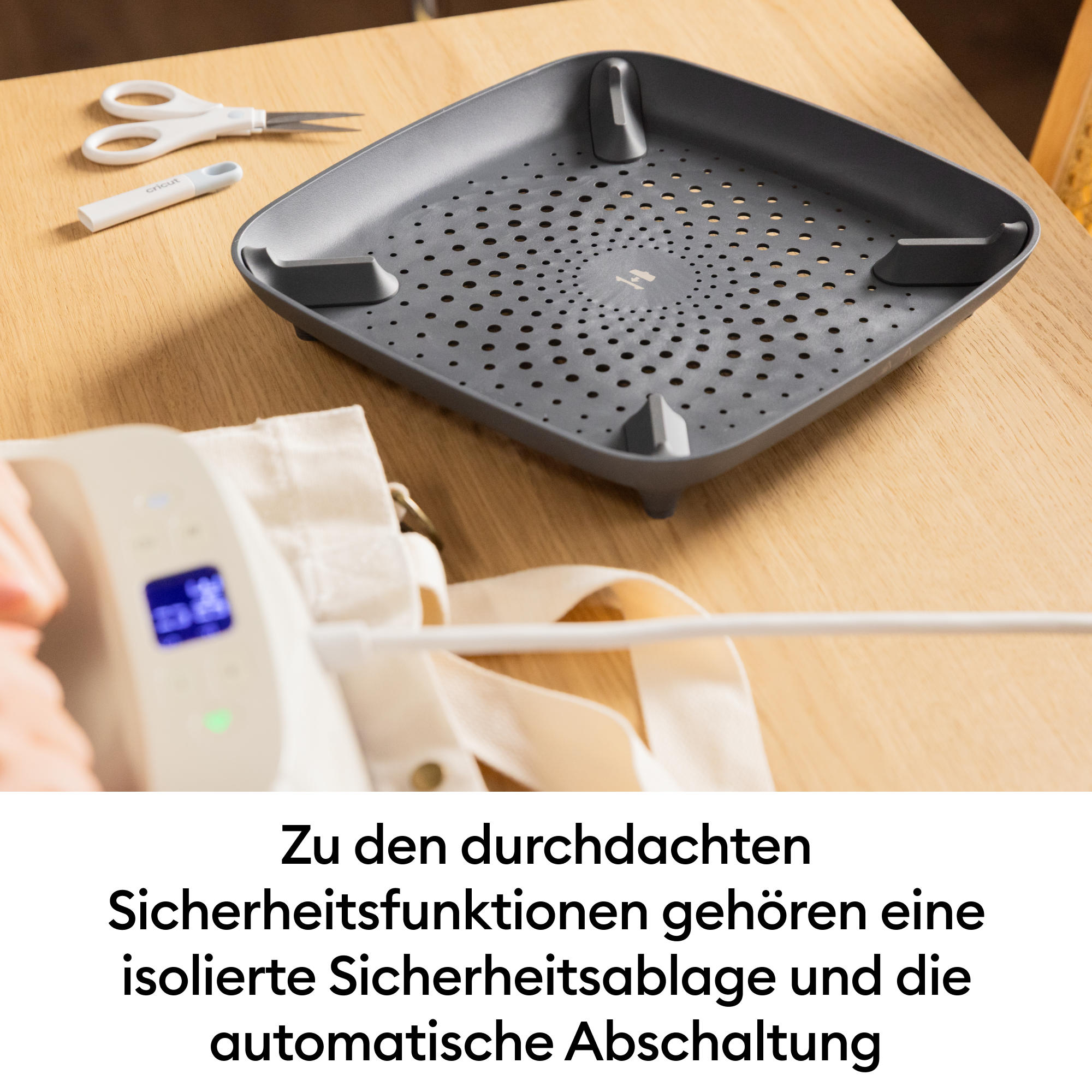 Eine weiße Schere und ein weißer Griff liegen neben einer grauen Schale.